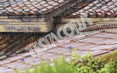 Pouring rain on tiles and gutters of a city roof (w/ sound)